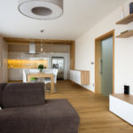 Kuchyně je opticky oddělena dřevěným pásem obloženým na stěně i stropu.