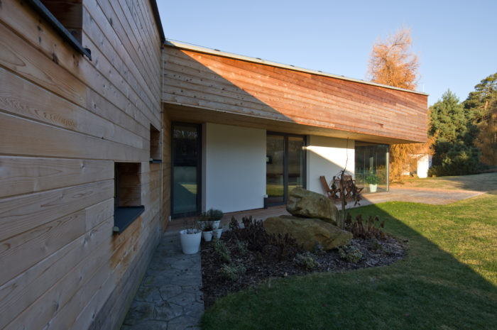 Převažujícím povrchem obou křídel domu je dřevěný obklad ve vodorovném členění.